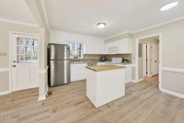 a kitchen with white cabinets and stainless steel appliances