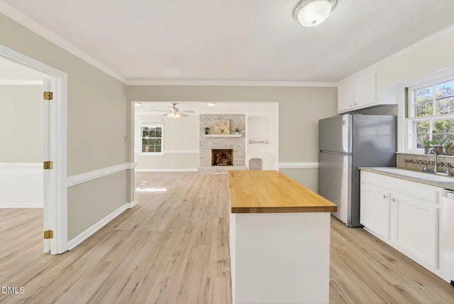 a open kitchen with a refrigerator stove and wooden floor