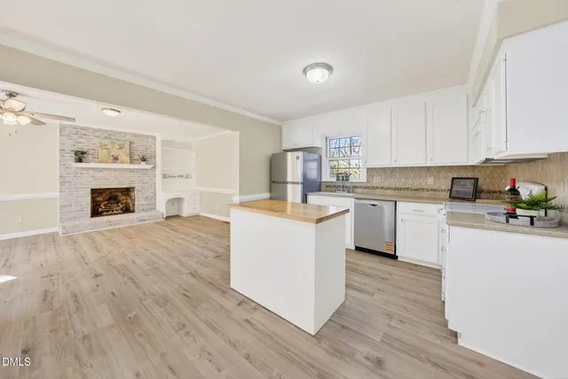 a kitchen with wooden floors and white stainless steel appliances