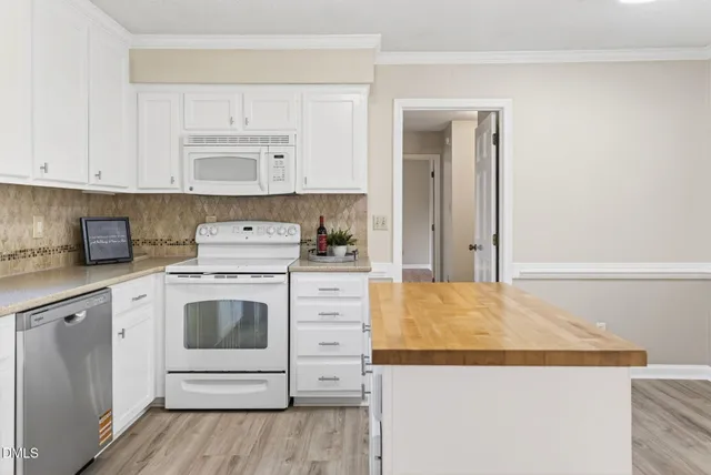 a kitchen with stainless steel appliances granite countertop a white stove top oven and white cabinets