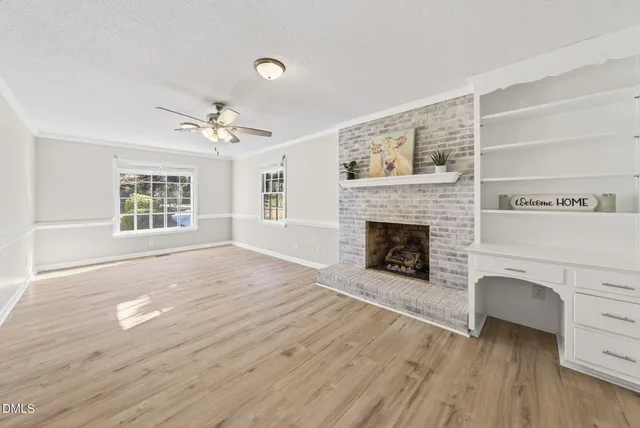a view of an empty room with a fireplace and a window