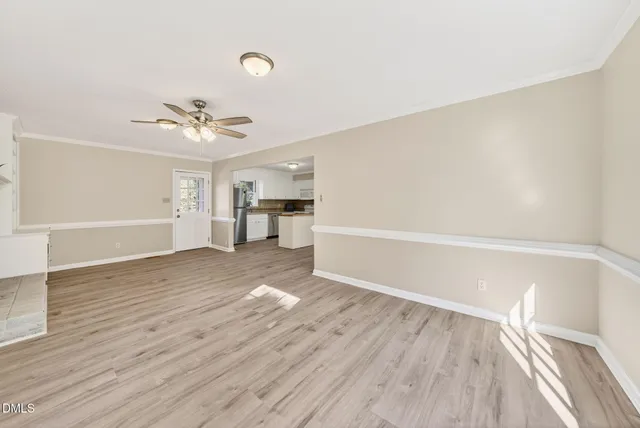 a view of empty room with wooden floor and ceiling fan