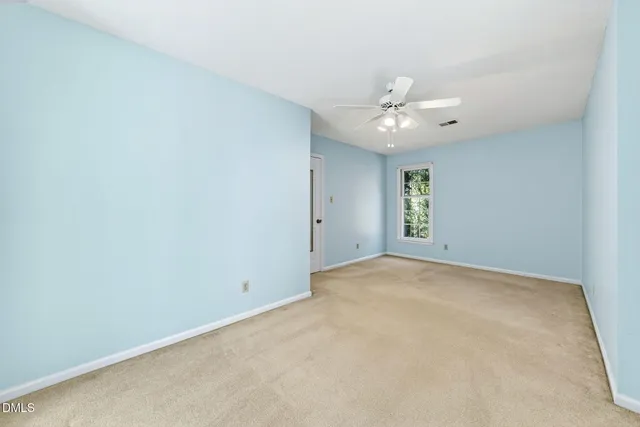 a view of an empty room with a ceiling fan