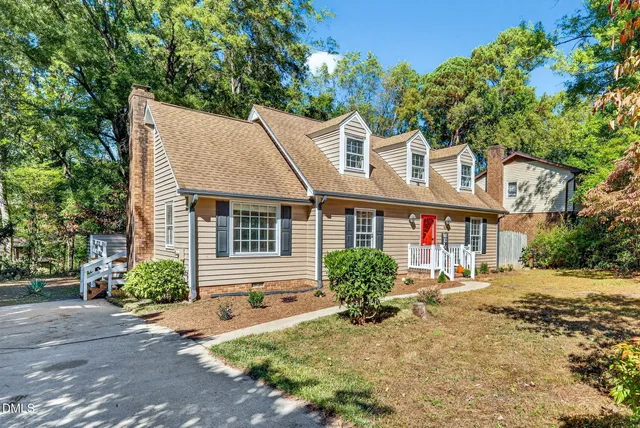 a front view of a house with a yard and potted plants