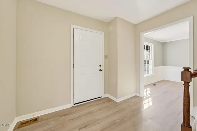 a view of empty room with wooden floor