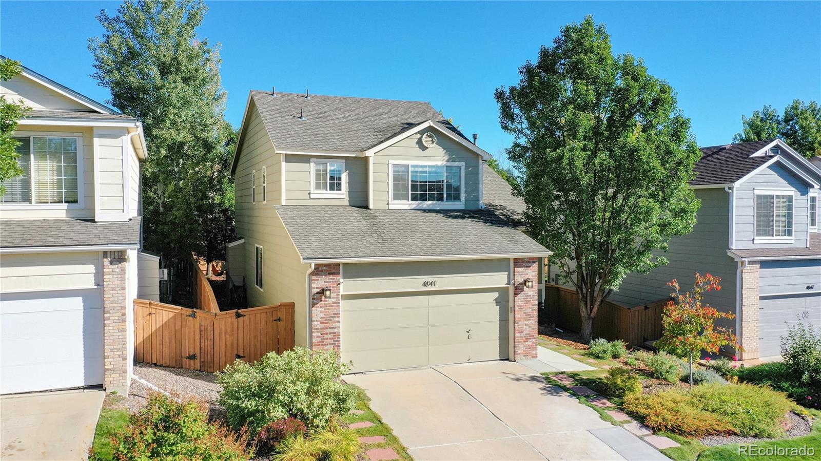 4841 Tarcoola Lane Highlands Ranch, CO 80130 - Photo 2 of 39 a front view of a house with a yard and garage
