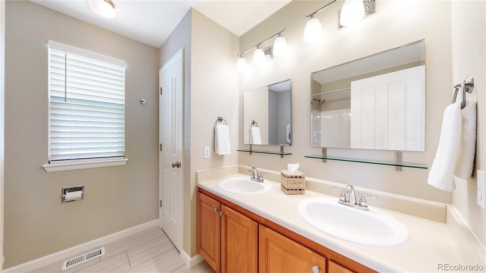 4841 Tarcoola Lane Highlands Ranch, CO 80130 - Photo 24 of 39 a bathroom with a double vanity sink and a mirror
