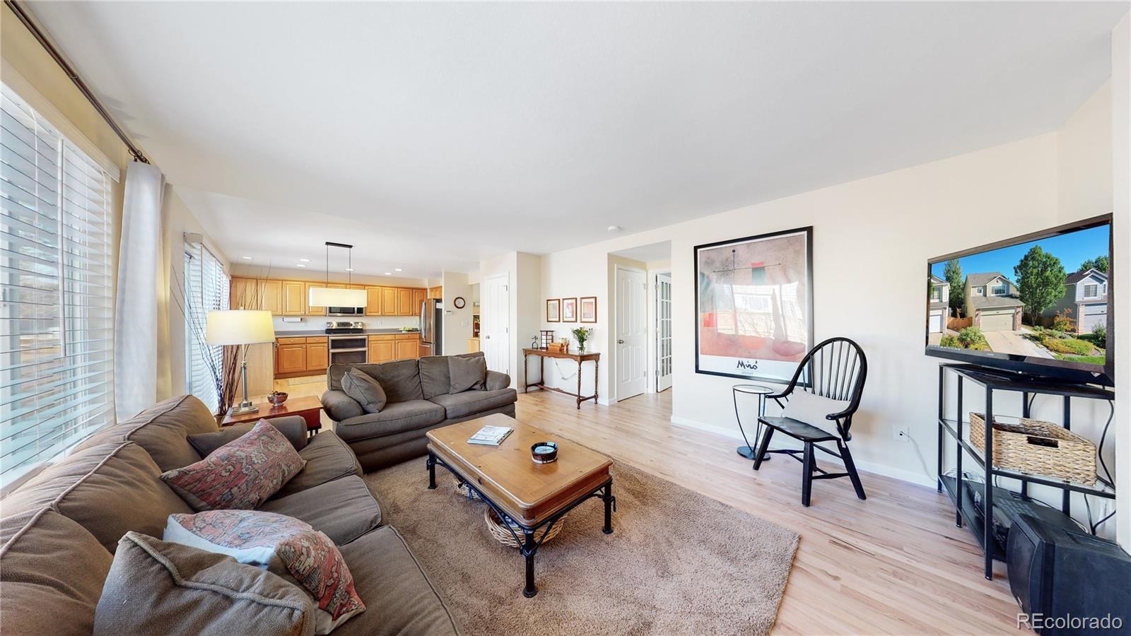 4841 Tarcoola Lane Highlands Ranch, CO 80130 - Photo 5 of 39 a living room with furniture a rug a table and a large window