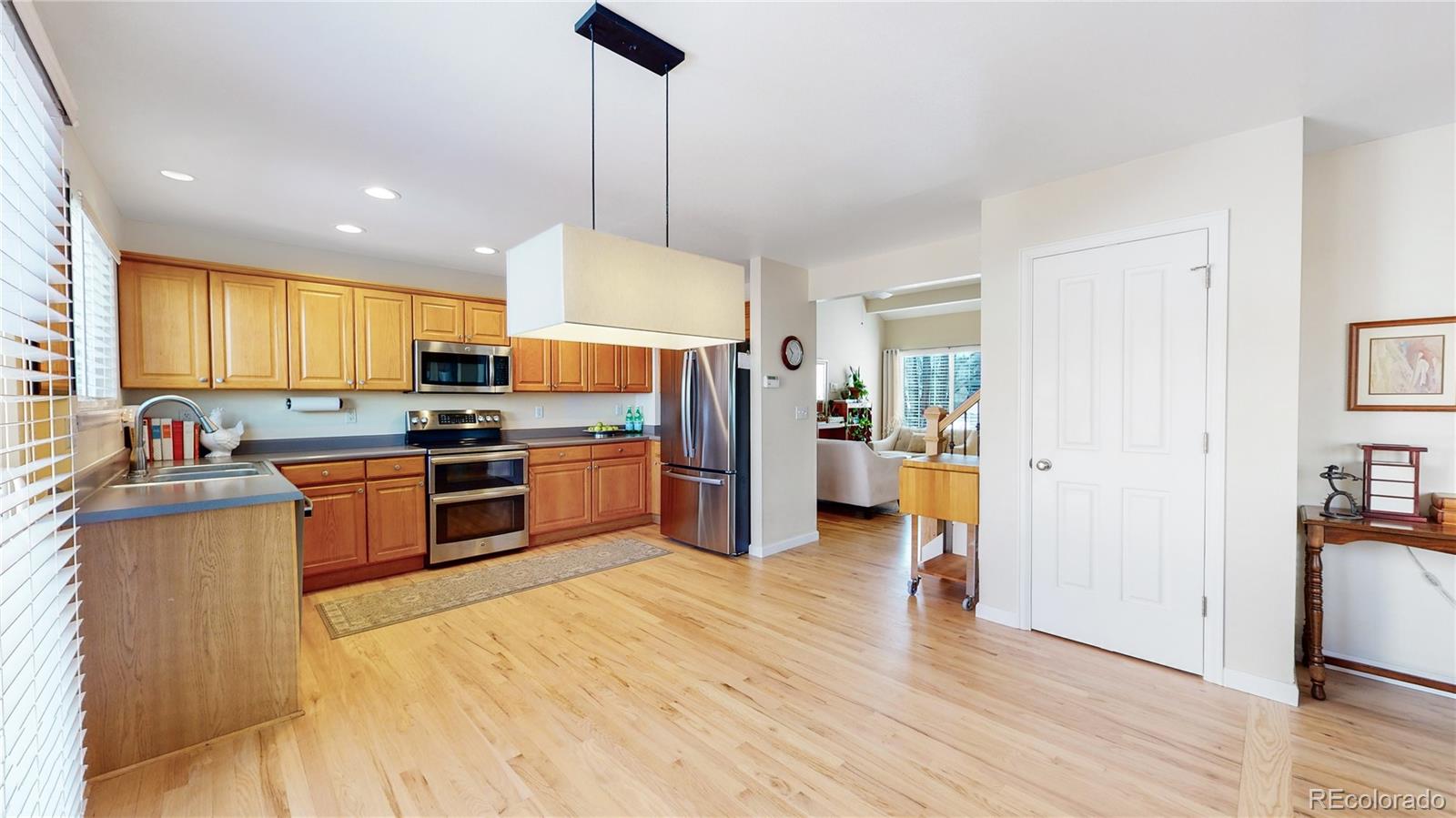 4841 Tarcoola Lane Highlands Ranch, CO 80130 - Photo 6 of 39 a kitchen with granite countertop stainless steel appliances and wooden cabinets