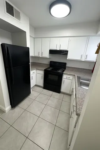 a kitchen with a refrigerator and a stove