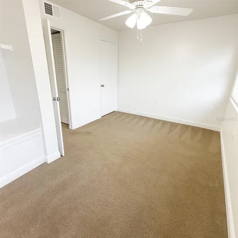 an empty room with a chandelier fan