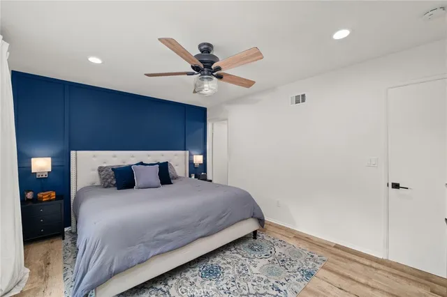 a bedroom with a bed and a ceiling fan