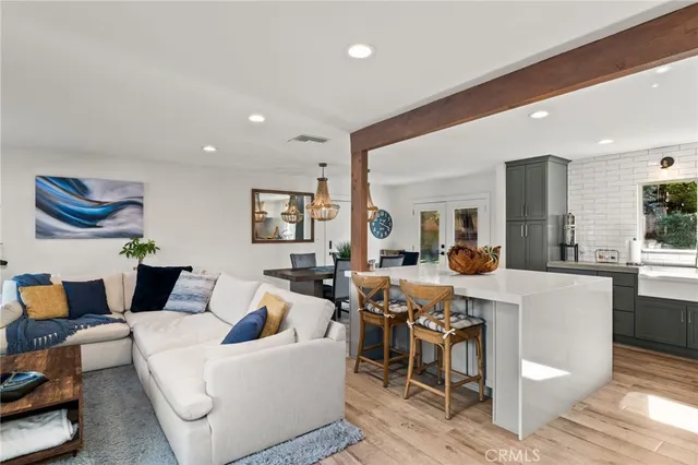 a living room with furniture a rug and kitchen view