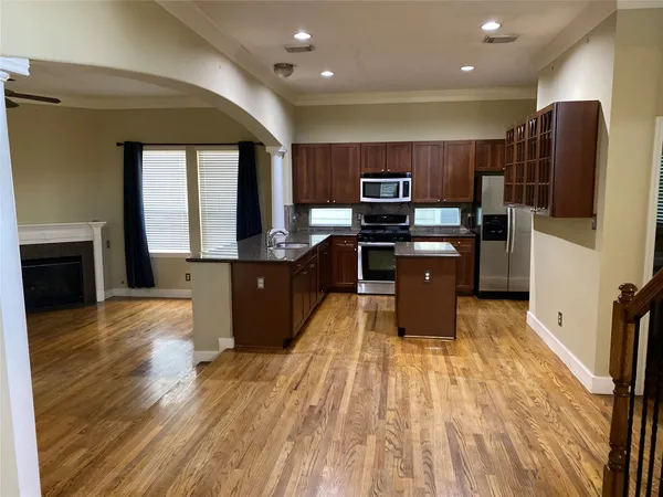 a kitchen with stainless steel appliances a refrigerator sink and wooden floor