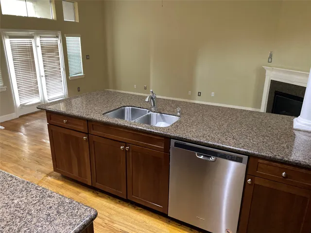 a kitchen with granite countertop a sink and a wooden cabinets