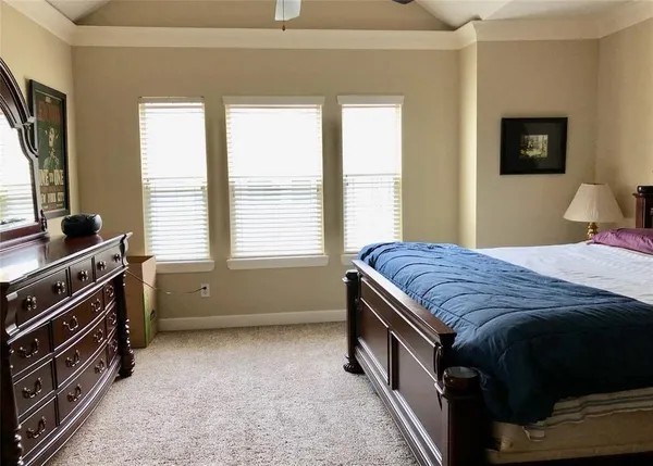 a bedroom with a bed and a flat tv screen on dresser