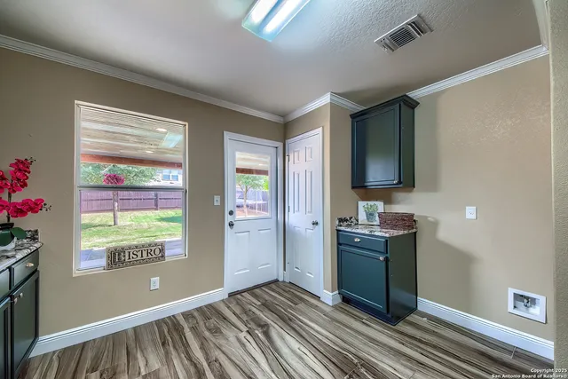 a view of an empty room with window and cabinet