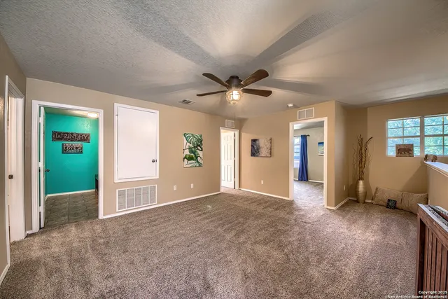 a view of an empty room with a ceiling fan