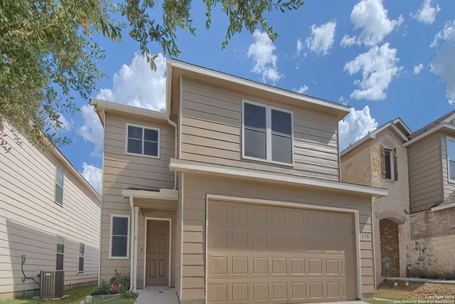 a front view of a house with a tree
