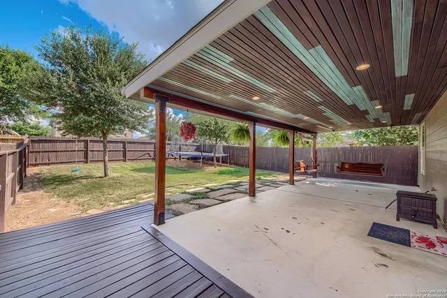 a view of a backyard with couches plants and wooden fence