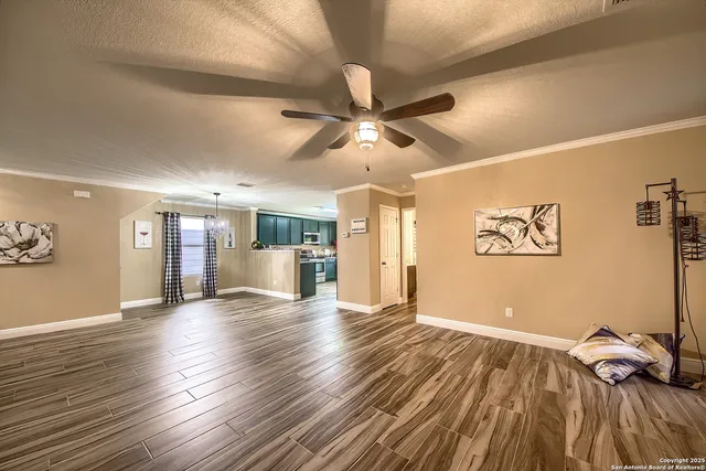 a view of an empty room with window and wooden floor