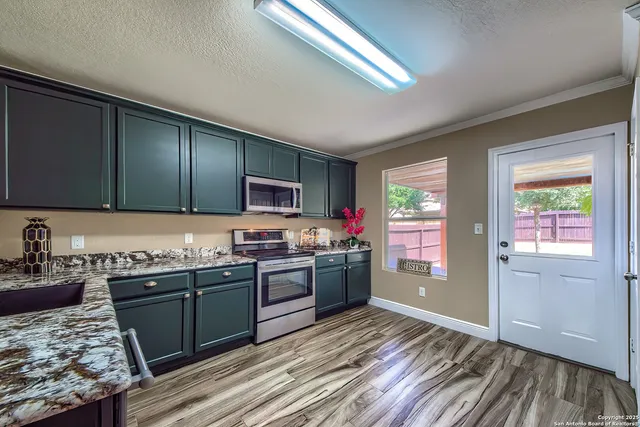 a kitchen with stainless steel appliances granite countertop a sink stove and refrigerator
