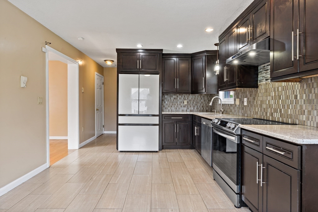 a kitchen with stainless steel appliances granite countertop a refrigerator a sink and a stove