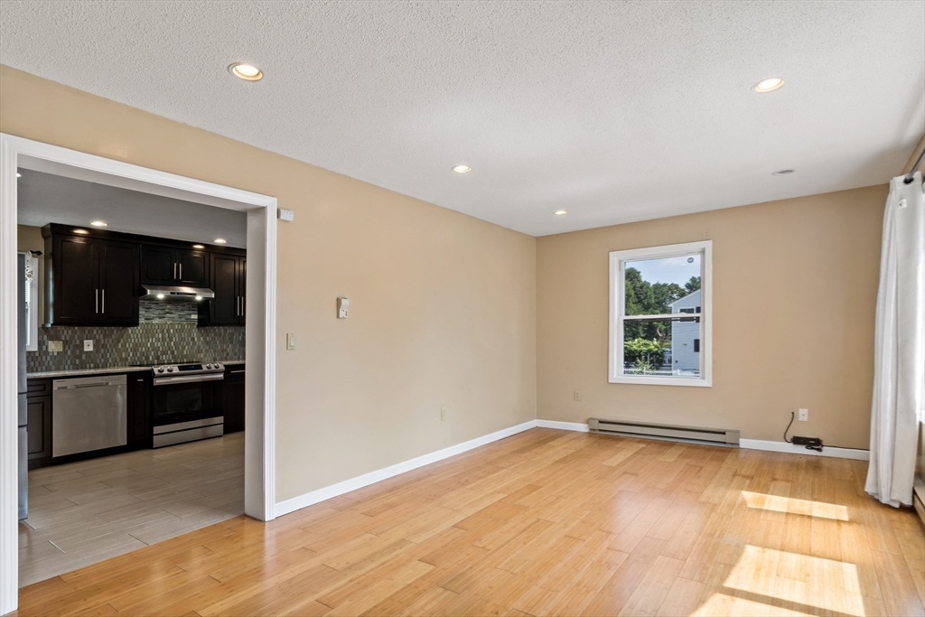 45 Fourth Street Worcester, MA 01602 - Photo 4 of 21 an empty room with kitchen and windows