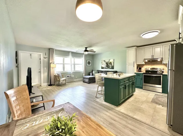 a large living room with stainless steel appliances granite countertop furniture and a kitchen view
