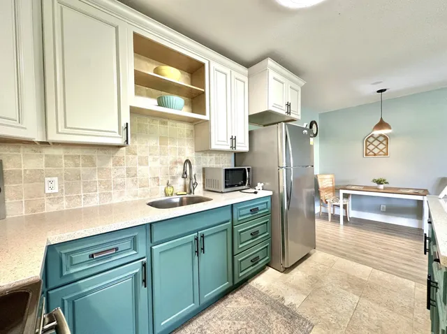 a kitchen with stainless steel appliances granite countertop a refrigerator and a stove top oven