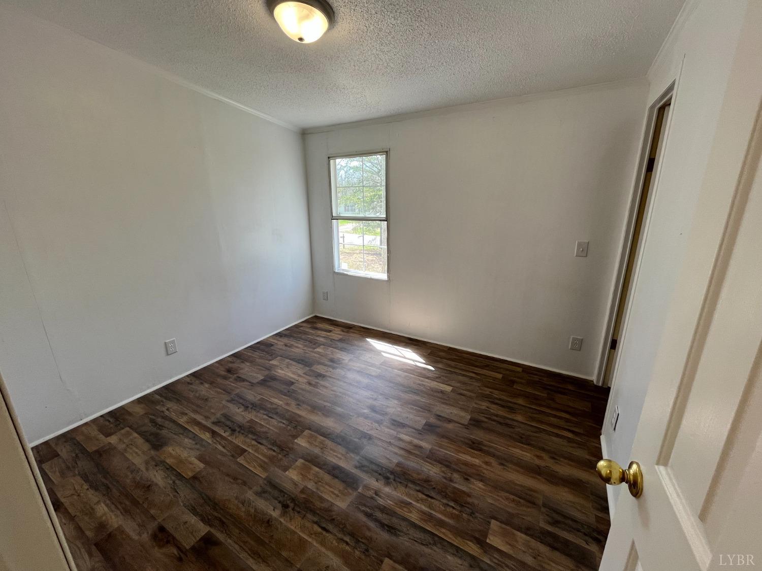 33 Pin Oak Court Evington, VA 24550 - Photo 14 of 19 a view of an empty room with wooden floor and a window
