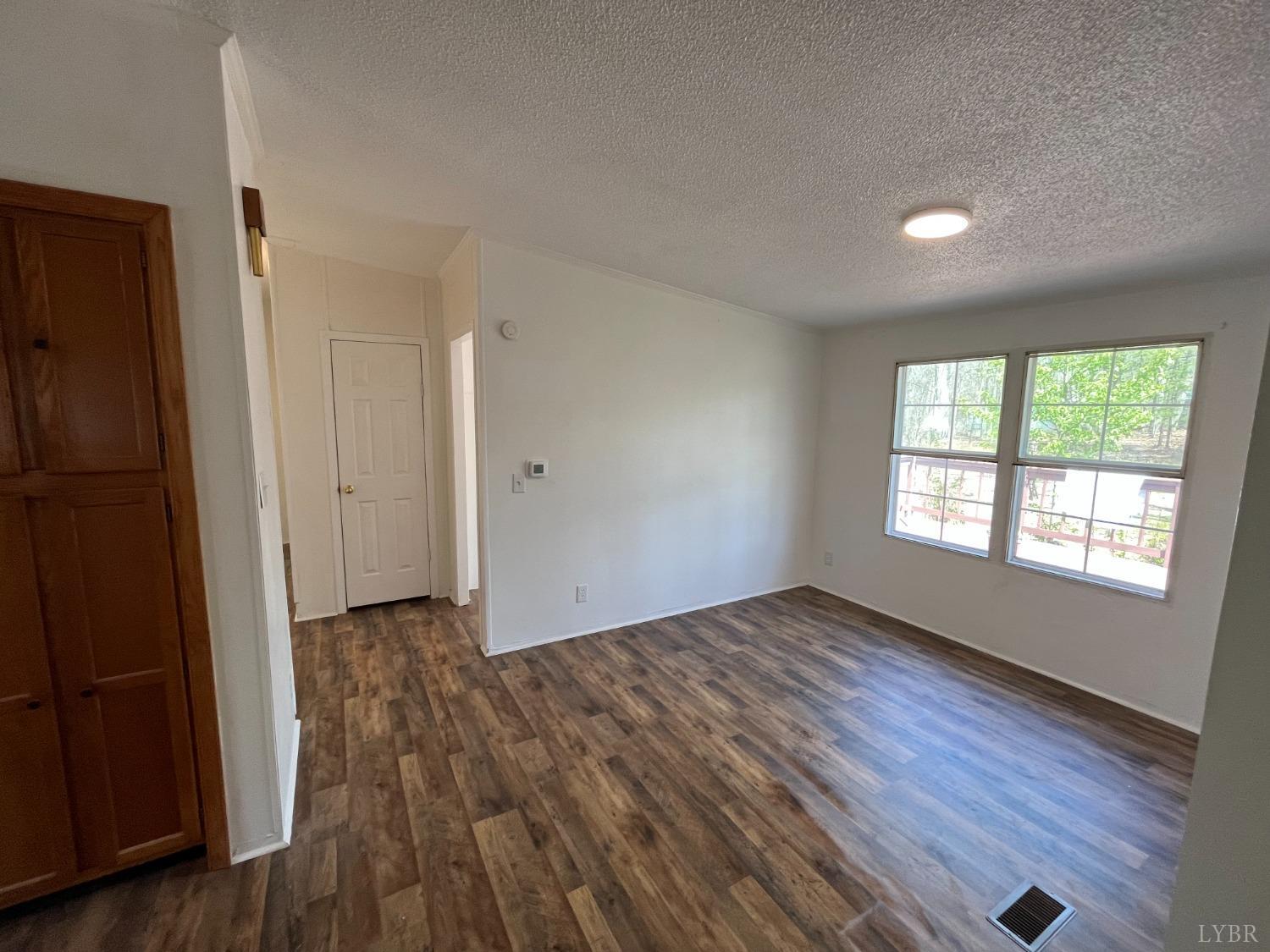 33 Pin Oak Court Evington, VA 24550 - Photo 9 of 19 an empty room with wooden floor and windows