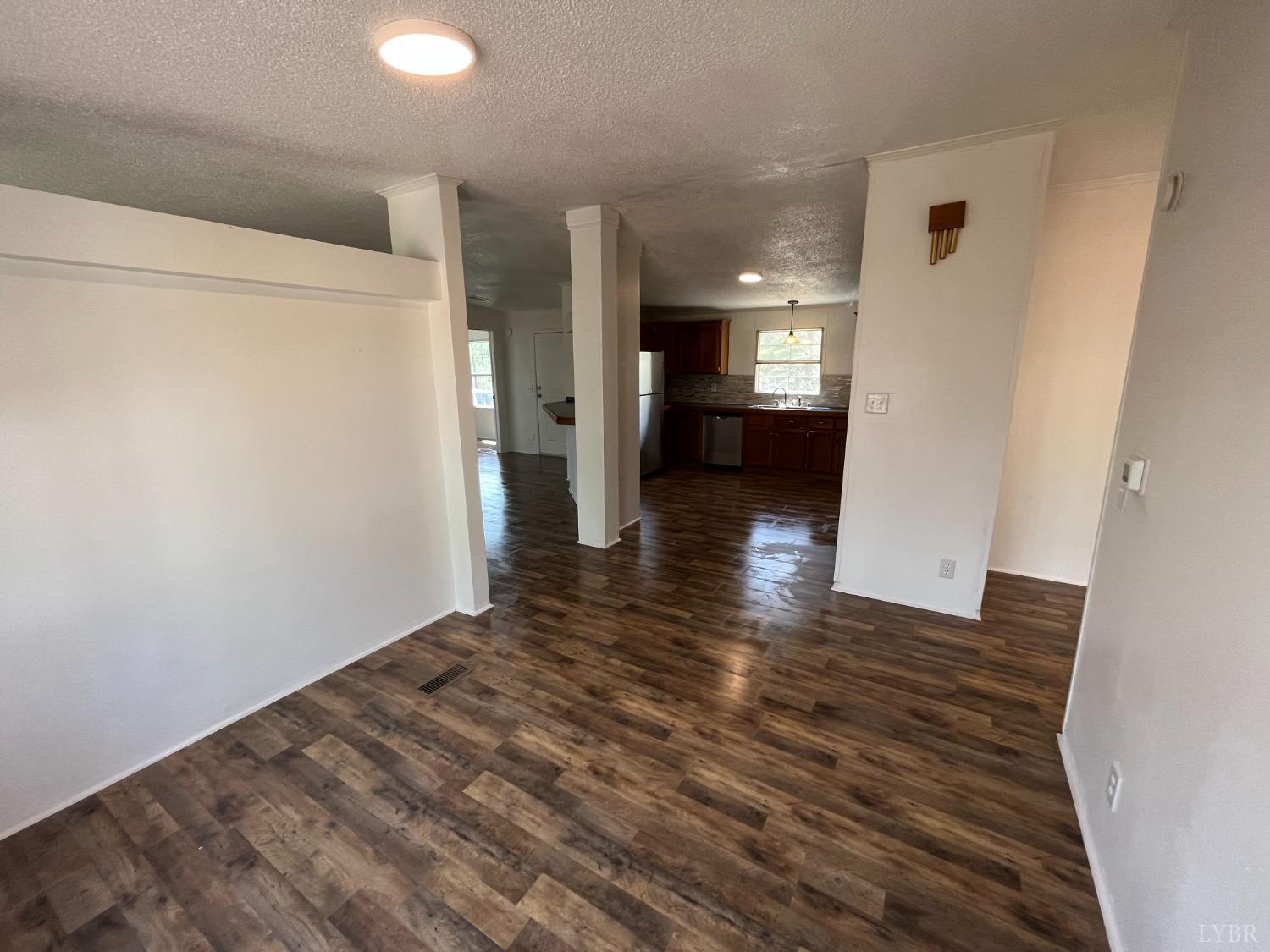 33 Pin Oak Court Evington, VA 24550 - Photo 10 of 19 a view of a hallway with wooden floor and a refrigerator
