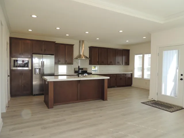 a kitchen with stainless steel appliances granite countertop a refrigerator and a sink