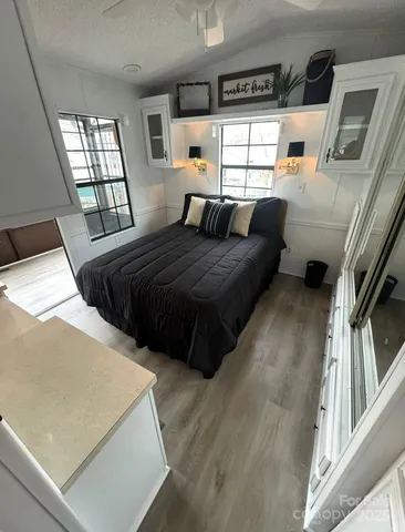 a bedroom with a bed and wooden floor