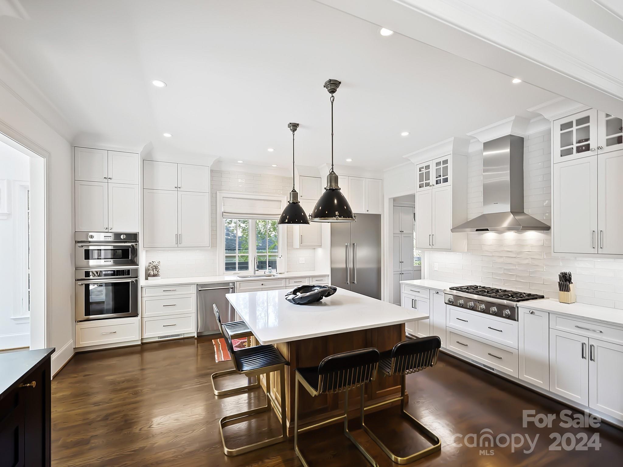 1621 Sterling Road Charlotte, NC 28209 - Photo 11 of 48 a kitchen with a stove a refrigerator and a dining table with wooden floor
