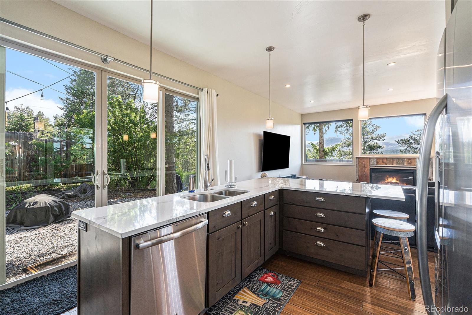4650 Forest Hill Road Evergreen, CO 80439 - Photo 12 of 36 a kitchen with stainless steel appliances granite countertop a sink and a large window