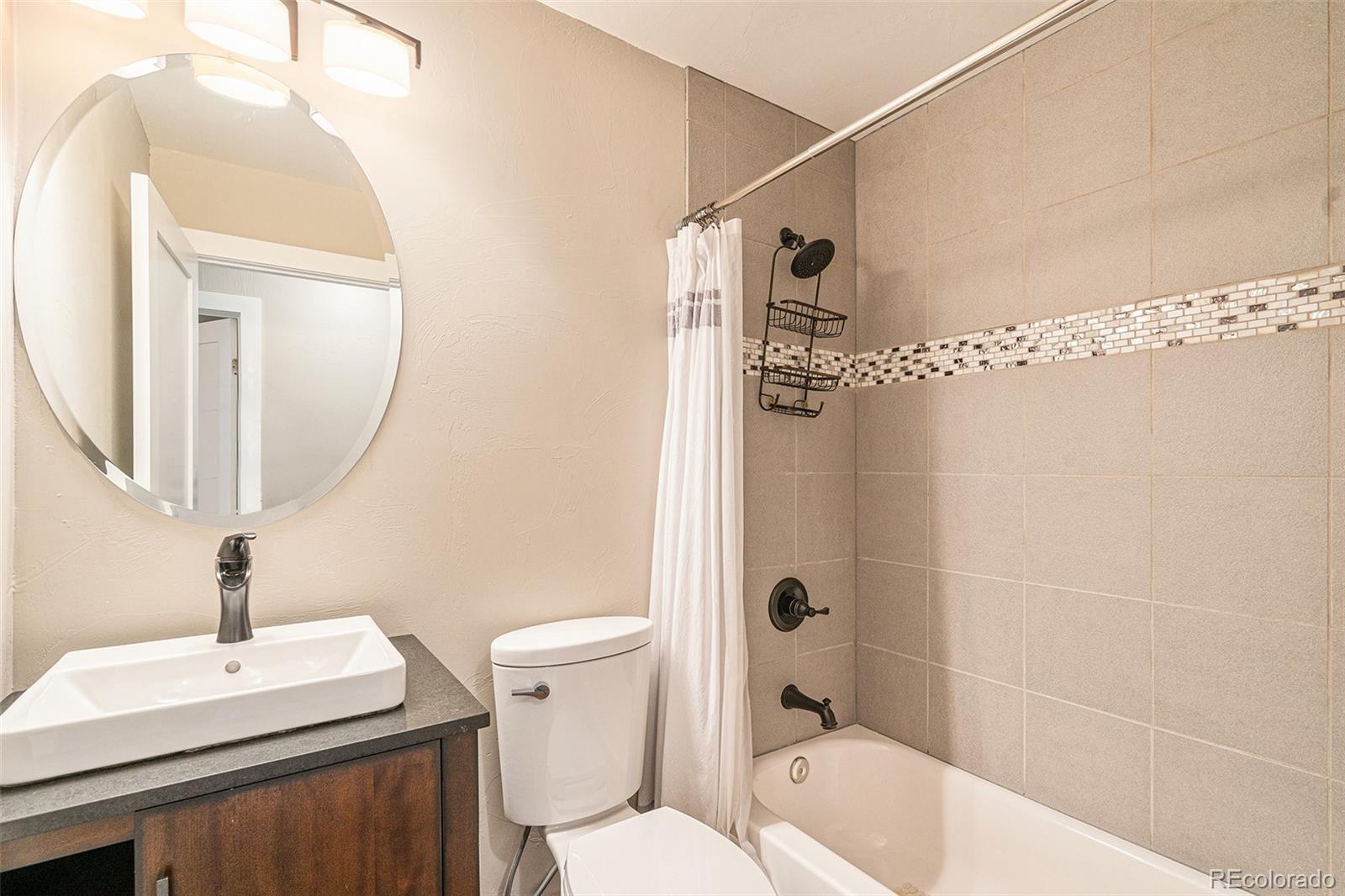 4650 Forest Hill Road Evergreen, CO 80439 - Photo 17 of 36 a bathroom with a sink a toilet and shower a mirror