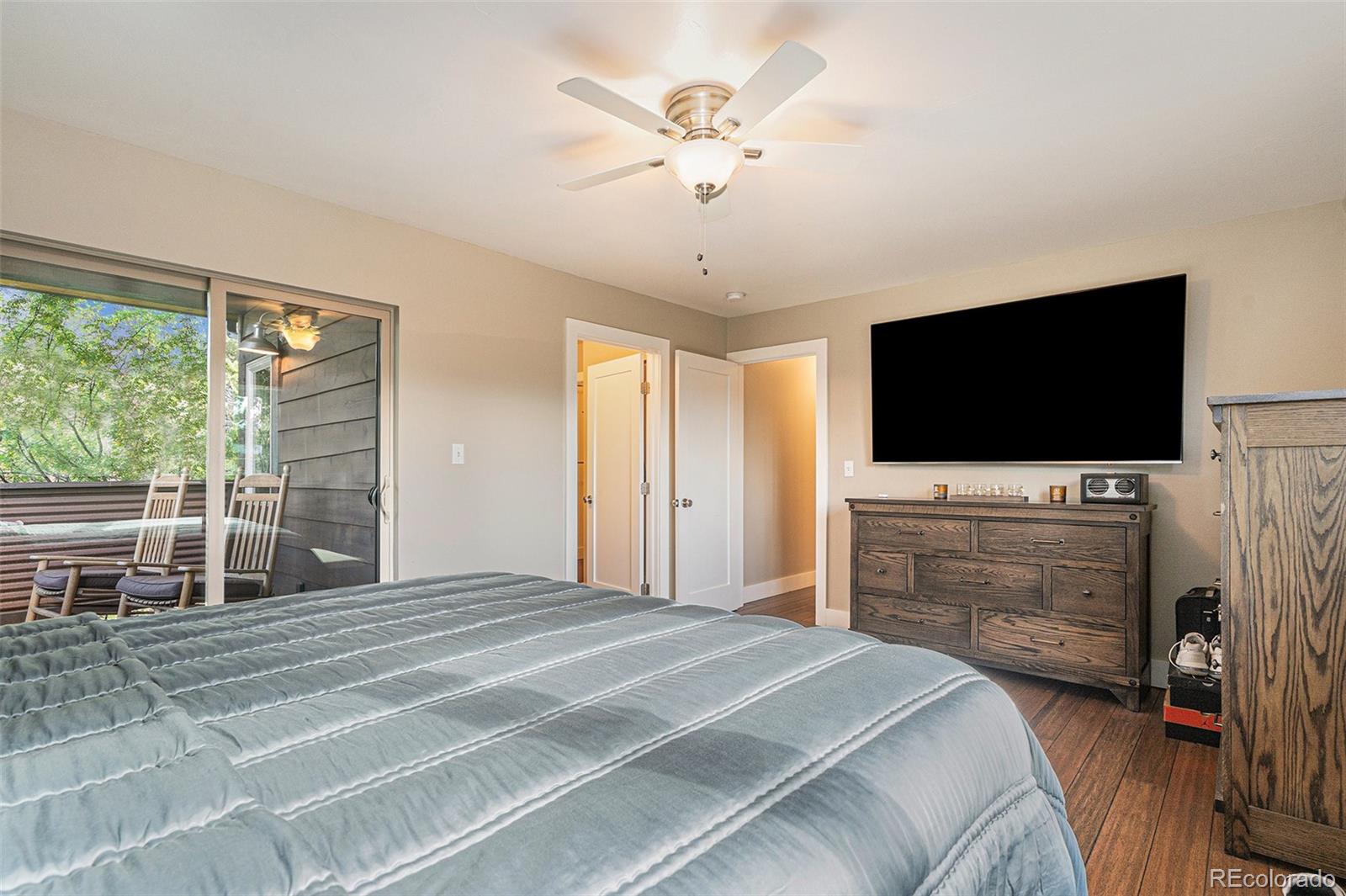 4650 Forest Hill Road Evergreen, CO 80439 - Photo 19 of 36 a bedroom with a bed and a flat screen tv