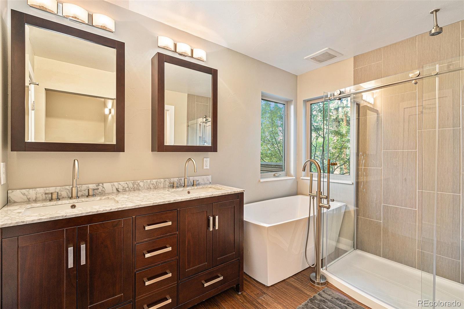 4650 Forest Hill Road Evergreen, CO 80439 - Photo 20 of 36 a bathroom with a double vanity sink a mirror and a bathtub
