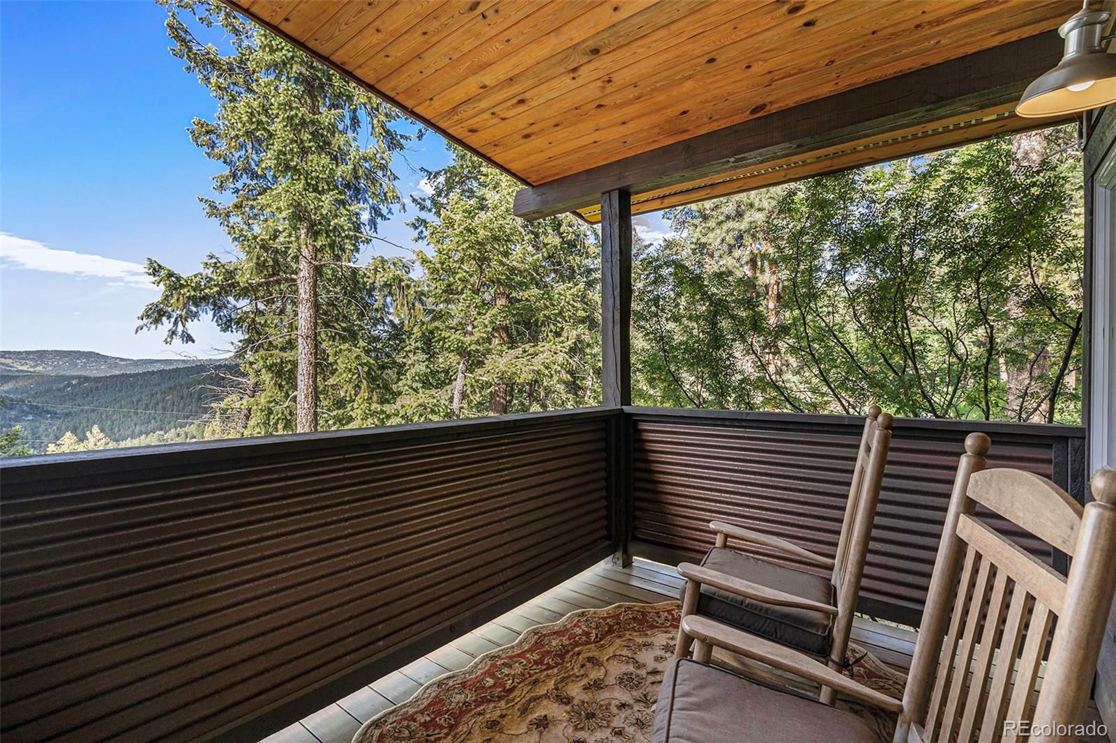 4650 Forest Hill Road Evergreen, CO 80439 - Photo 22 of 36 a view of a balcony with wooden floor and fence