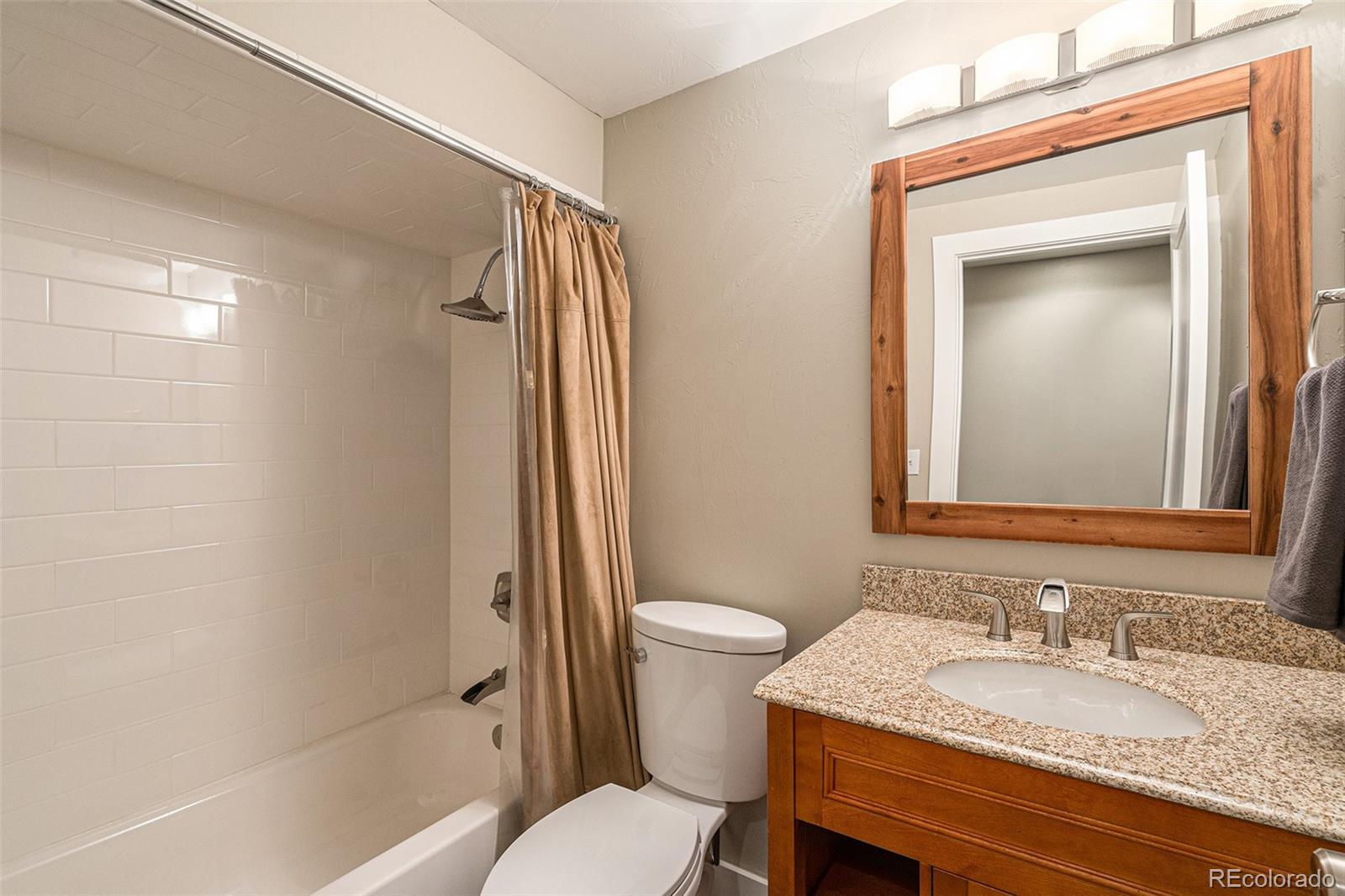 4650 Forest Hill Road Evergreen, CO 80439 - Photo 23 of 36 a bathroom with a granite countertop sink toilet and shower