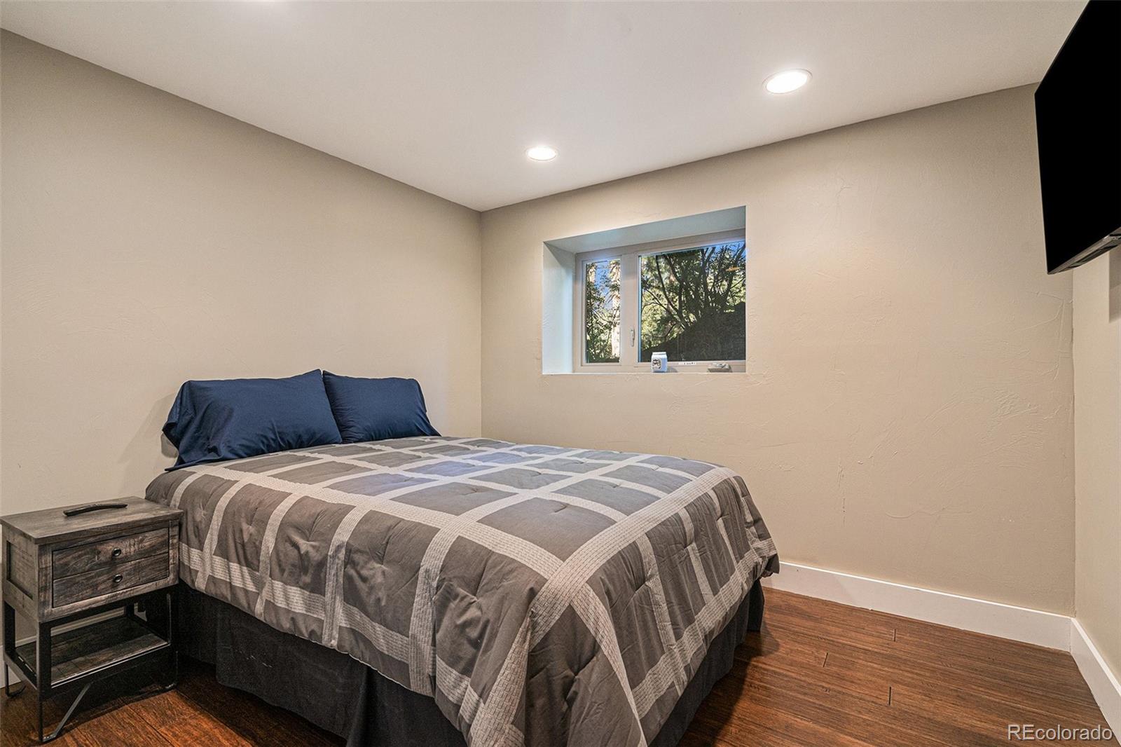 4650 Forest Hill Road Evergreen, CO 80439 - Photo 24 of 36 a bedroom with a bed and a flat screen tv