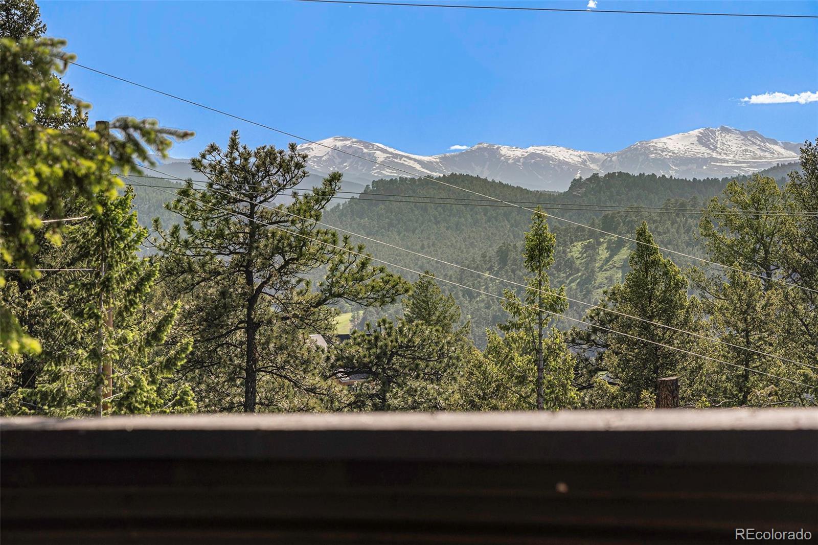 4650 Forest Hill Road Evergreen, CO 80439 - Photo 28 of 36 a view of a lot of trees from a balcony