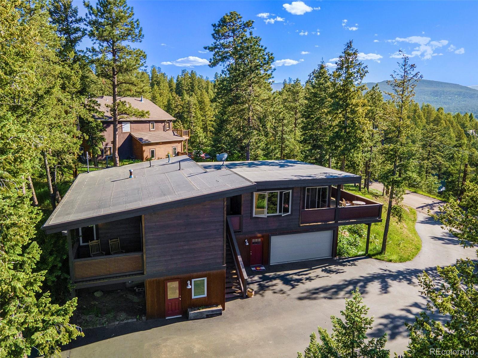 4650 Forest Hill Road Evergreen, CO 80439 - Photo 3 of 36 a view of a wooden house with a yard