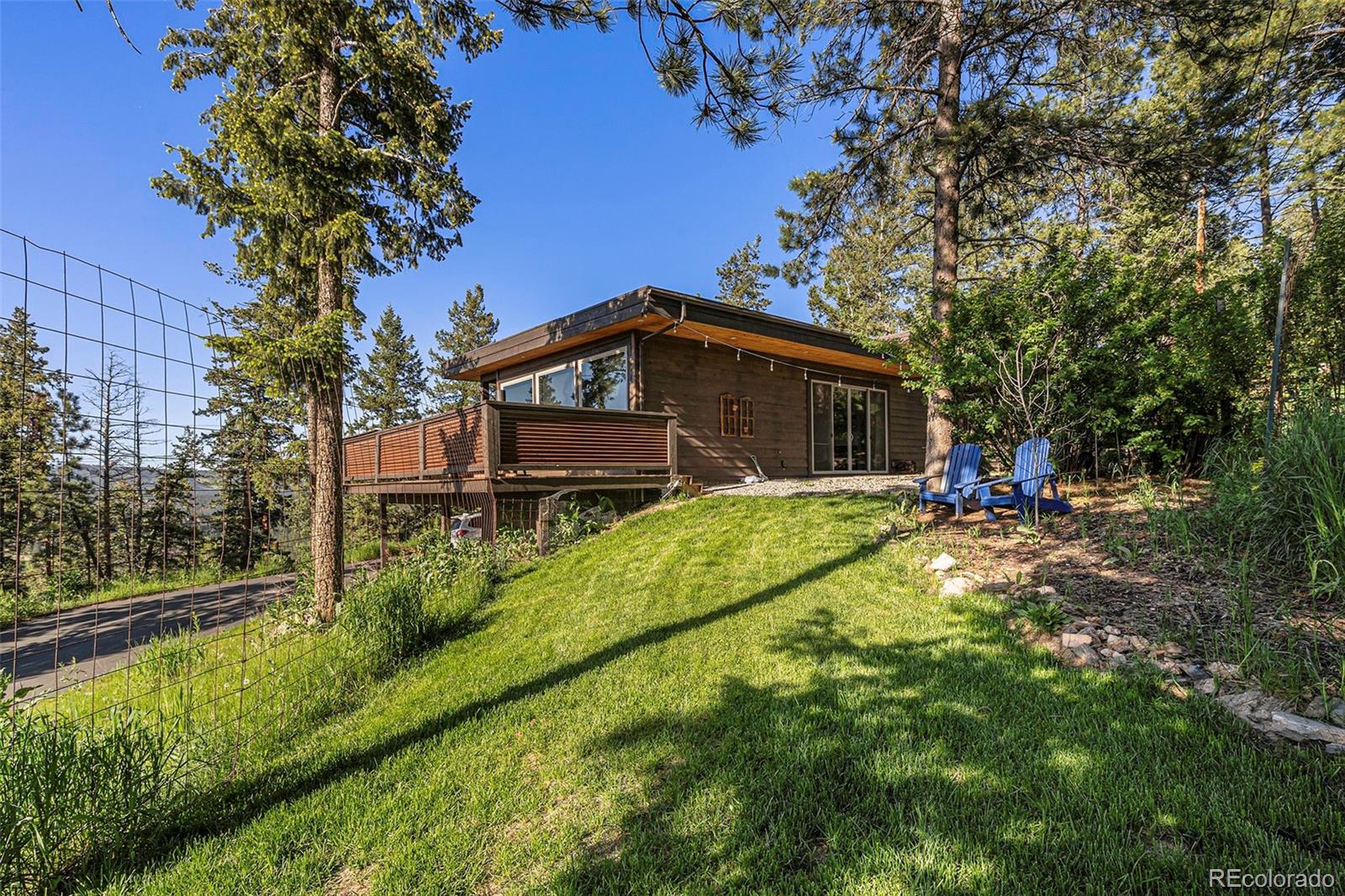 4650 Forest Hill Road Evergreen, CO 80439 - Photo 34 of 36 a view of a house with backyard and sitting area