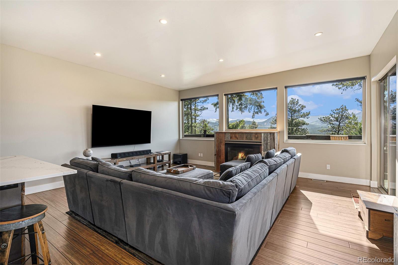 4650 Forest Hill Road Evergreen, CO 80439 - Photo 5 of 36 a living room with furniture a flat screen tv and a large window