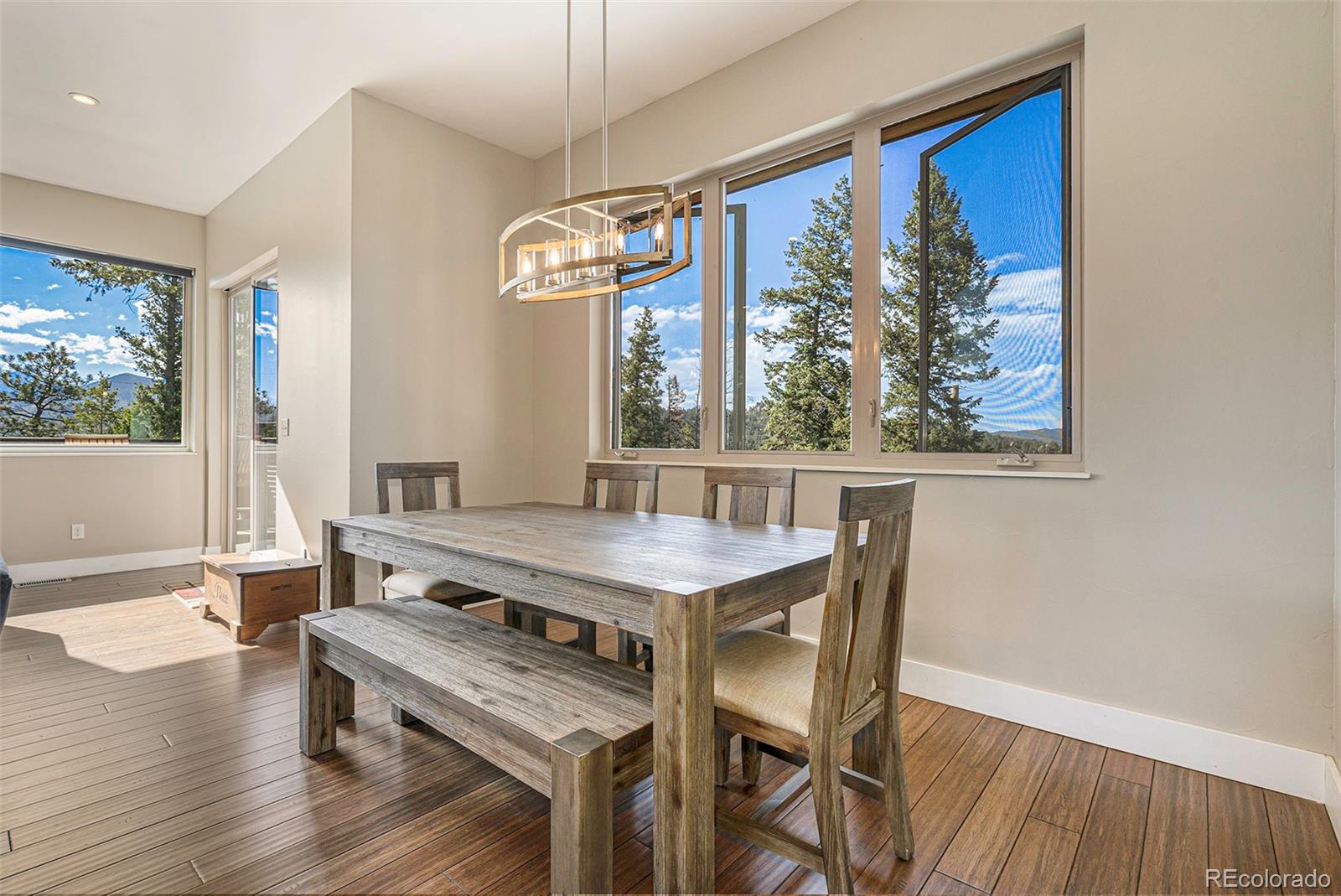 4650 Forest Hill Road Evergreen, CO 80439 - Photo 8 of 36 a view of a dining room with furniture large window and wooden floor