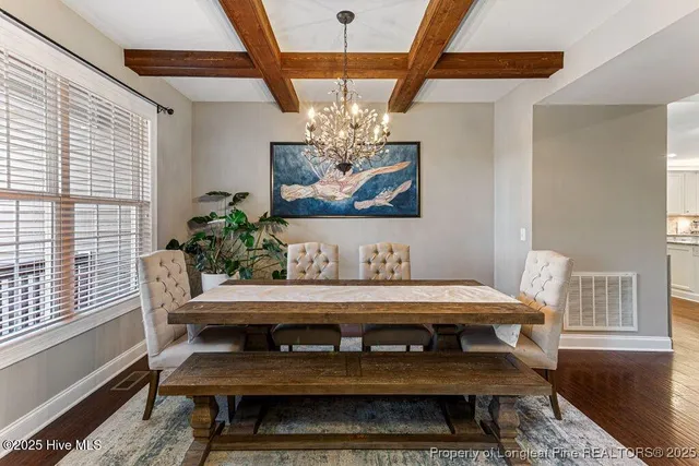 a dining room with furniture a chandelier and wooden floor