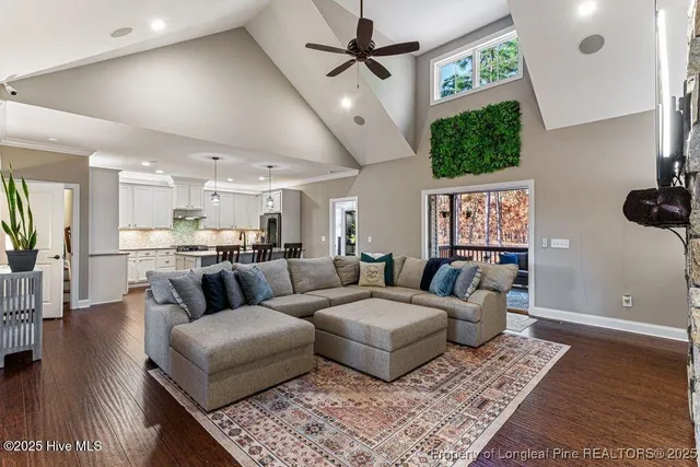 a living room with furniture a fireplace and a floor to ceiling window